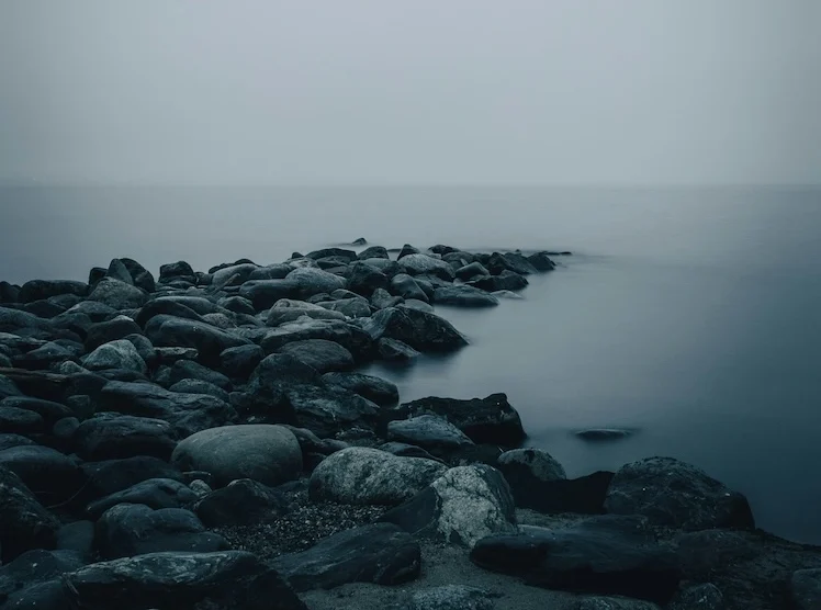 Keien die vanaf het strand de zee in lopen, als beeld voor samenhang en verschillende perspectieven.